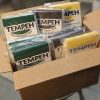 A 10lb box of retail packaged tempeh varieties - soy, black-eyed pea, and yellow pea tempeh